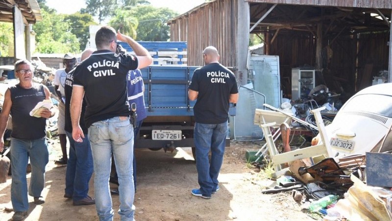 Foto um de desmanche de veículos que mostra policiais civis em ação na força-tarefa, em Eldorado do Sul