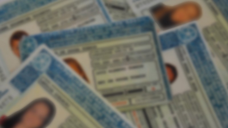 Foto desfocada de várias CNHs dispostas sobre uma mesa