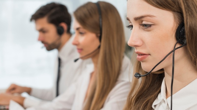 Pessoas trabalhando em um call center com headsets