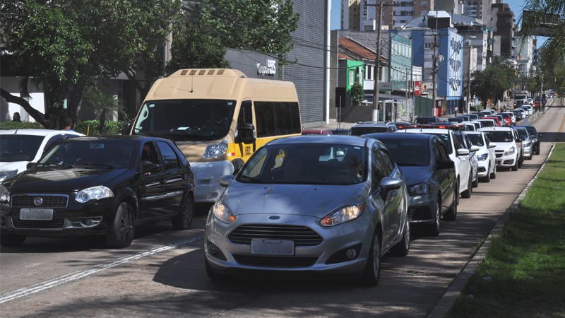 Fila de carros em uma grande avenida parados na sinaleira