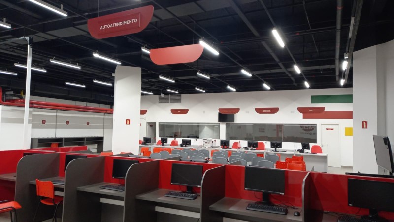 Sala de atendimento  ao público com guichês e bancos de espera