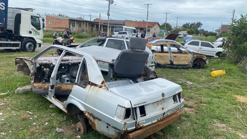 A foto mostra carcaças de veículos ao ar livre, na 104ª Op. Desmanche