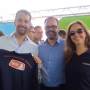 Imagem do Governador Eduardo Leite segurando a camiseta da Balada Segura, ao lado do diretor-geral adjunto do DetranRS Rafael Mennet e da coordenadora da Balada pelo DetranRS, Luciane Ninki