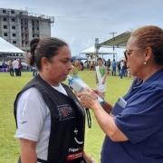 Uma mulher sopra o bafômetro, segurado pela agente de fiscalização do DetranRS