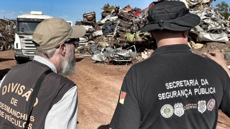 Foto do p&aacute;tio onde est&atilde;o dispostas as sucatas veiculares, onde dois servidores que atuam na opera&ccedil;&atilde;o est&atilde;o de costas