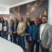 Foto horizontal colorida mostra quatro homens e quatro mulheres posando de pé para foto