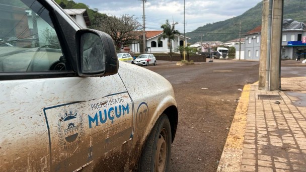 Veículo branco sujo de barro, da prefeitura de muçum, em via do município.