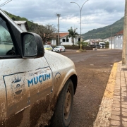 Veículo branco sujo de barro, da prefeitura de muçum, em via do município.