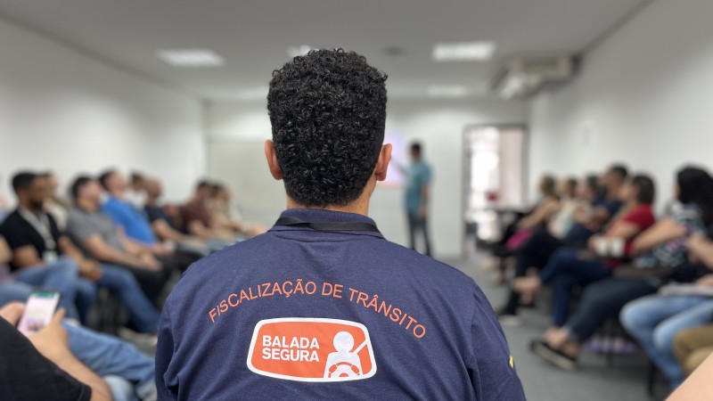 agente com uniforme da balada segura de costas e fora de foco círculo de agentes assistindo à apresentação.