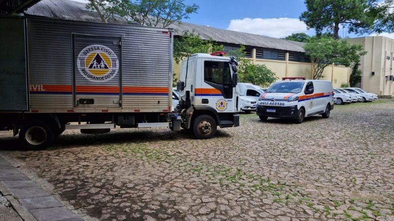caminhão e furgão da defesa civil estacionados