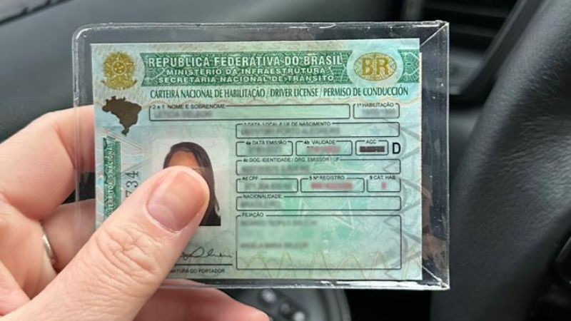 mão esquerda segurando uma CNH