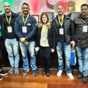 Servidores do DetranRS que atuam na Balada Segura, em pé, em frente ao palco do evento, junto com a diretora Diza Gonzaga 
