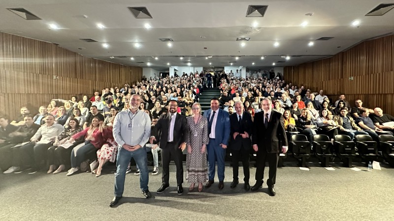Egídio, Fábio, Cláudia, Sessim, professor Eduardo e Edir em pe', em frente a platéia formada por diretores de ensino de CFC