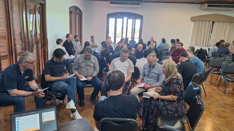 Participantes reunidos em pequenos grupos, realizando as atividades