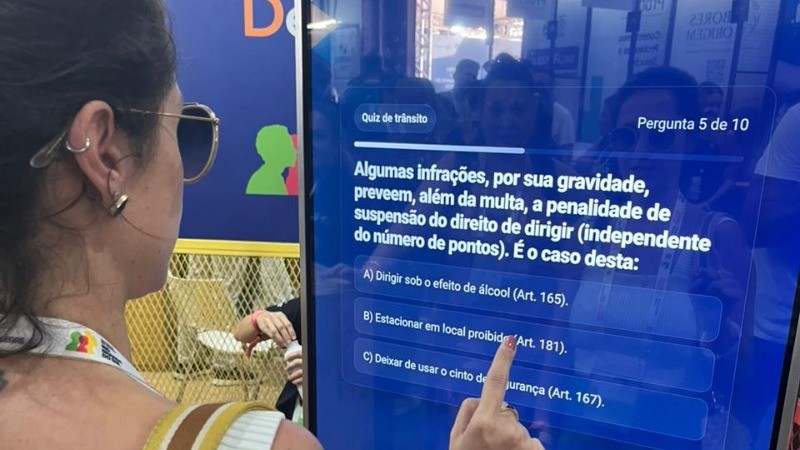 Mulher respondendo o quiz do DetranRS, no totem do estande, no South Summit Brazil